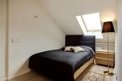 a small bedroom with a black bed and a window at #stayhere - Spacious 2BDR Two Floor I Heart of Old Town in Vilnius