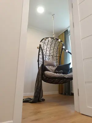 a wicker chair in a room with a door at Dariaus ir Girėno 6 Apartments in Vilnius