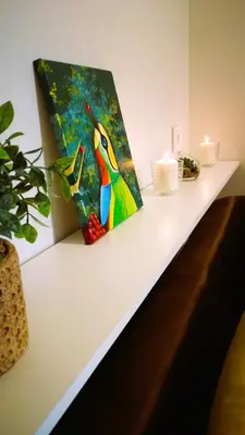 a painting of a colorful bird on a counter with candles at Dariaus ir Girėno 6 Apartments in Vilnius