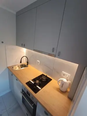 a kitchen with white cabinets and a stove and a sink at Dariaus ir Girėno 6 Apartments in Vilnius