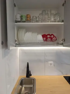 a kitchen with a sink and a shelf with dishes at Dariaus ir Girėno 6 Apartments in Vilnius