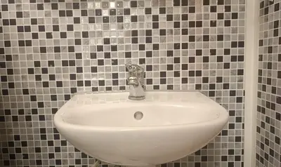a white sink in a tiled bathroom at Dariaus ir Girėno 6 Apartments in Vilnius