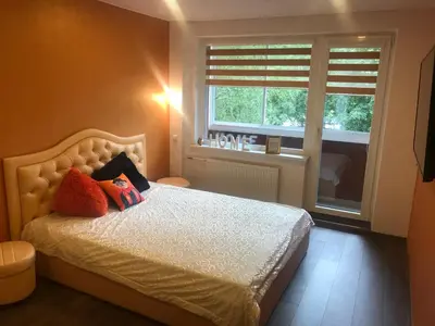a bedroom with a bed with two pillows and a window at Trumpalaikė buto nuoma Rokiškyje su jacuzzi in Rokiškis