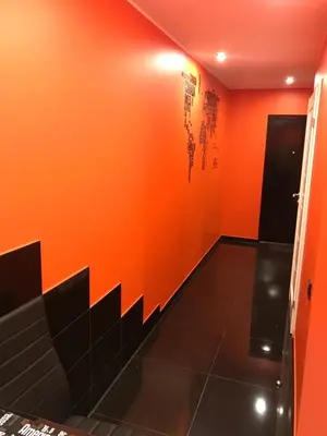 a room with orange walls and black tile floors at Trumpalaikė buto nuoma Rokiškyje su jacuzzi in Rokiškis