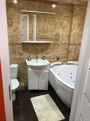 a bathroom with a tub and a sink and a toilet at Trumpalaikė buto nuoma Rokiškyje su jacuzzi in Rokiškis