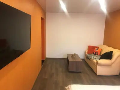 a living room with a couch and a flat screen tv at Trumpalaikė buto nuoma Rokiškyje su jacuzzi in Rokiškis
