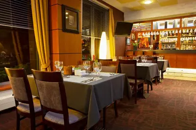 a dining room with tables and chairs with wine glasses at Art City Inn in Vilnius
