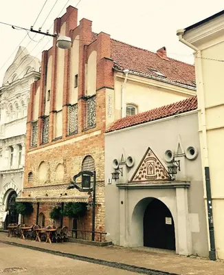 an old building with an archway in a street at St Palace Hotel in Vilnius