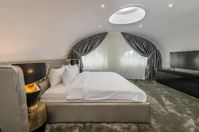 a bedroom with a white bed with a large window at St Palace Hotel in Vilnius