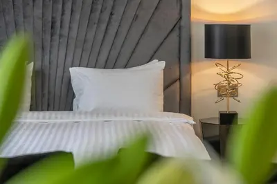 a bed with a white pillow and a lamp at St Palace Hotel in Vilnius