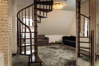 a spiral staircase in a living room with a couch at St Palace Hotel in Vilnius