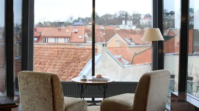 a room with two chairs and a table and large windows at BEST WESTERN Santakos Hotel in Kaunas