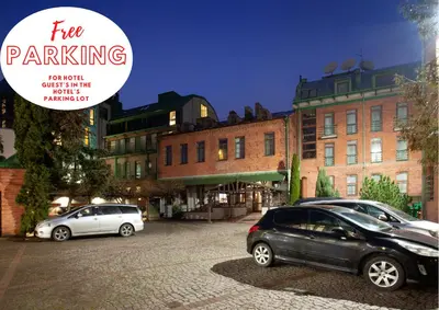 two cars parked in a parking lot in front of buildings at BEST WESTERN Santakos Hotel in Kaunas