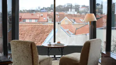 a room with two chairs and a table and large windows at BEST WESTERN Santakos Hotel in Kaunas