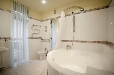 a white bathroom with a tub and a toilet at BEST WESTERN Santakos Hotel in Kaunas