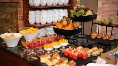 a buffet of food with fruit and drinks on a table at BEST WESTERN Santakos Hotel in Kaunas