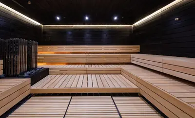 an empty sauna with wooden benches and lights at Vilnius Grand Resort in Ežeraičiai