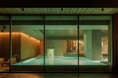 a large swimming pool in a building with a person in it at Vilnius Grand Resort in Ežeraičiai