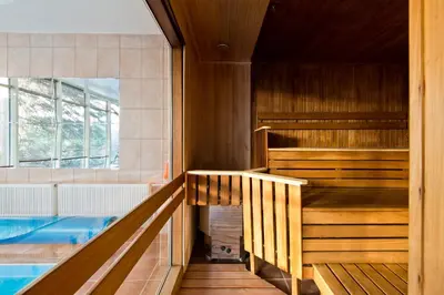a sauna with a tub and a swimming pool at Best Western Vilnius in Vilnius