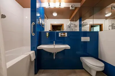 a blue and white bathroom with a sink and a toilet at Best Western Vilnius in Vilnius