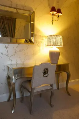 a desk with a lamp and a chair in a room at Hotel Apia in Vilnius