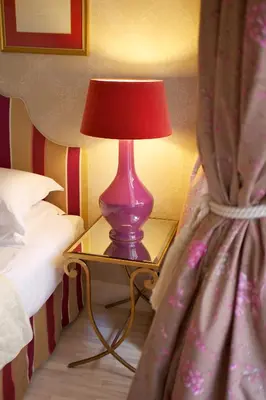 a purple lamp on a table next to a bed at Hotel Apia in Vilnius