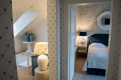 a bedroom with a bed and a table and a mirror at Hotel Apia in Vilnius