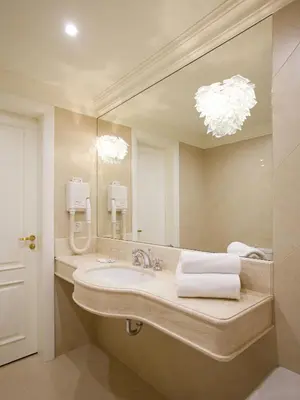 a bathroom with a sink and a large mirror at Hotel Apia in Vilnius