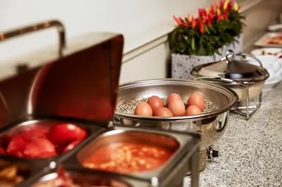 a kitchen counter with bowls of food and eggs at Ratonda Centrum Hotels in Vilnius