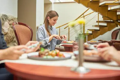 a group of people sitting at a table eating food at Ratonda Centrum Hotels in Vilnius