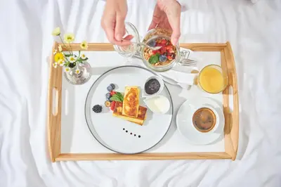 a tray with a plate of food and a cup of coffee at Ratonda Centrum Hotels in Vilnius