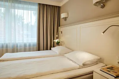 a bedroom with a white bed with a window at Ratonda Centrum Hotels in Vilnius
