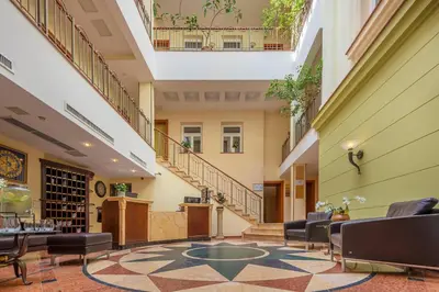 a lobby with a staircase and chairs and a table at Artis Centrum Hotels in Vilnius
