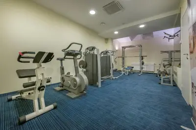 a gym with treadmills and machines in a room at Artis Centrum Hotels in Vilnius