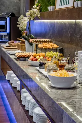 a buffet line with bowls of fruit and other food at VILNIUS PARK PLAZA HOTEL & SPA, Restaurant, Panorama Bar, Conference & Banquet Center in Vilnius
