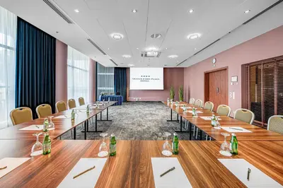 a conference room with long tables and chairs at VILNIUS PARK PLAZA HOTEL & SPA, Restaurant, Panorama Bar, Conference & Banquet Center in Vilnius