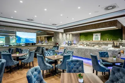 a restaurant with tables and chairs and a bar at VILNIUS PARK PLAZA HOTEL & SPA, Restaurant, Panorama Bar, Conference & Banquet Center in Vilnius