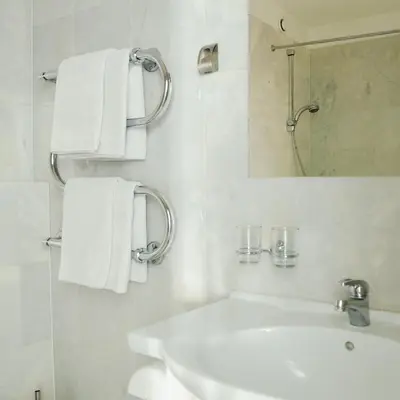 a bathroom with a sink and a mirror and towels at Amicus Hotel in Vilnius