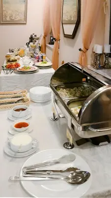 a buffet with plates of food on a table at Amicus Hotel in Vilnius
