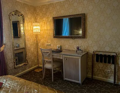 a bedroom with a desk and a bed and a mirror at Imperial Hotel & Restaurant in Vilnius