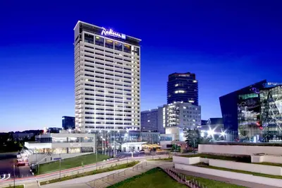 a tall building with a sign on it in a city at Radisson Blu Hotel Lietuva in Vilnius