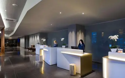 two women standing at a counter in a lobby at Radisson Blu Hotel Lietuva in Vilnius