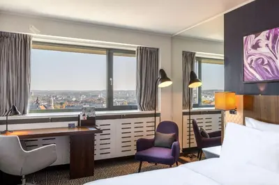 a hotel room with a bed and a desk and chairs at Radisson Blu Hotel Lietuva in Vilnius