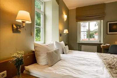 a bedroom with a white bed with a window at Mabre Residence in Vilnius