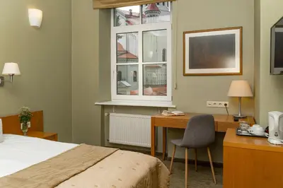 a bedroom with a desk and a bed and a window at Mabre Residence in Vilnius