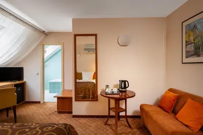 a hotel room with a couch and a mirror at Mabre Residence in Vilnius