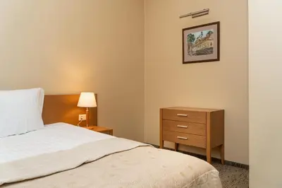 a bedroom with a bed and a dresser and a picture at Mabre Residence in Vilnius