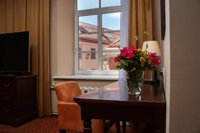 a vase of flowers on a table in front of a window at Mabre Residence in Vilnius