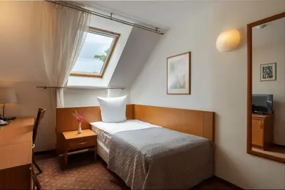 a small bedroom with a bed and a window at Mabre Residence in Vilnius