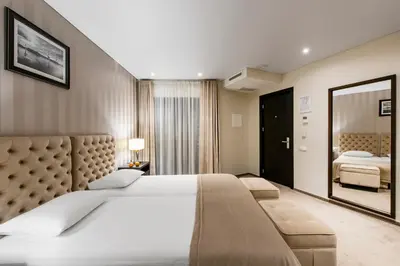 a bedroom with a large bed and a mirror at Amberton Cathedral Square Hotel Vilnius in Vilnius